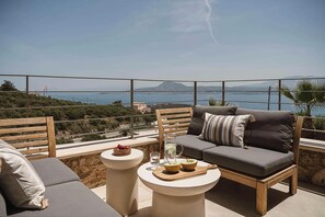 A terrace with a sofa, a table, and a bowl of fruit.