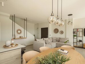 A modern living room with a dining table, sofa, and decorative items. - Villa Niolos II, Near Marathi Beach with eco pool (Chania)