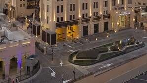 A multi-story hotel with a modern architectural design, featuring balconies and a well-lit entrance.