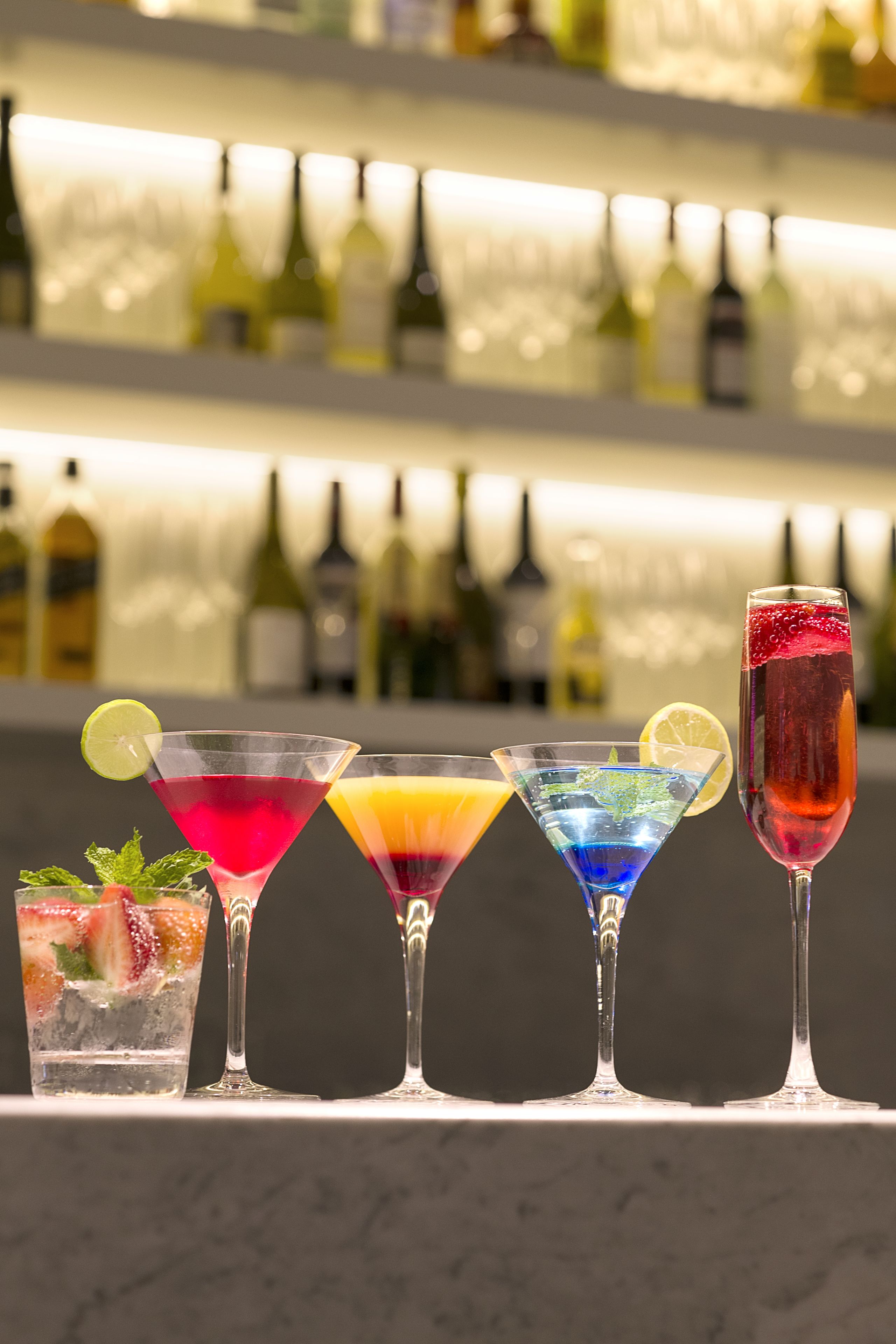 A bar with various cocktails and bottles in the background.