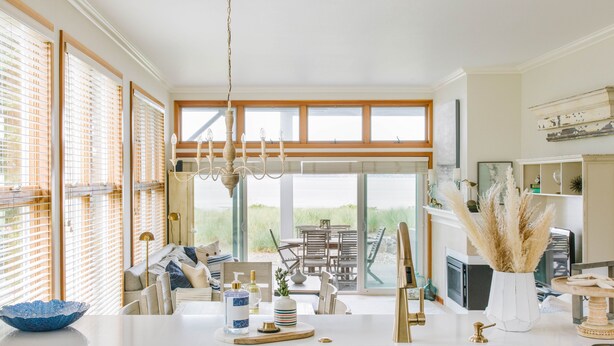 A modern kitchen with a large island, a dining area with a view, and a living space with a fireplace. - Beachfront Getaway in Semiahmoo (Blaine)