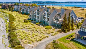 A coastal residential area with modern houses, a beach, and a mountain in the background. - Beachfront Getaway in Semiahmoo (Blaine)