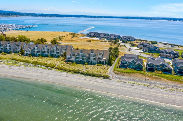 A coastal residential area with modern houses, a marina, and a clear view of the water.