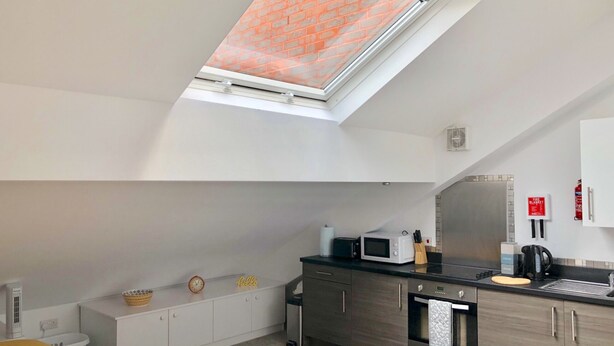 A modern kitchen with a skylight, a microwave, a coffee machine, and a fire extinguisher. - Toothbrush Apartments - Central Ipswich East - Rope Walk (Ipswich)