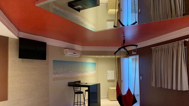 Ein modernes Hotelzimmer mit einem Bett, einem Schreibtisch und einem Hängesessel.