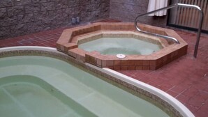 A swimming pool with a hot tub area.