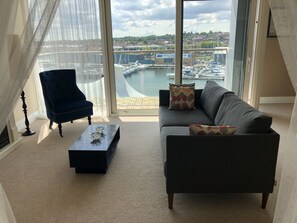 A living room with a view of a marina and buildings. - Toothbrush Apartments - Ipswich Waterfront - Anchor St (Ipswich)