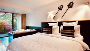 A modern bedroom with a large bed, a built-in bathtub, and a balcony with a view of trees. - Centrally located 2-bedroom luxury villa in Australia’s spa country (Hepburn Springs)