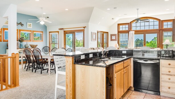 A spacious kitchen with a large island, wooden cabinets, and a dishwasher. - Love R Shack: Oceanside Duplex, Spa, Shared Pool (Corolla)