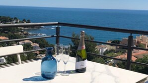 A balcony with a table set for two, overlooking a coastal view. - Spectacular apartment with fantastic panoramic views (Llançà)