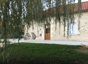 A building with a stone facade, a wooden door, and a window.