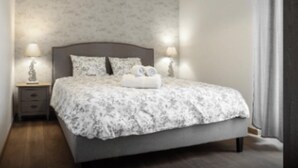 Une chambre à coucher avec un lit, des tables de chevet et des lampes.