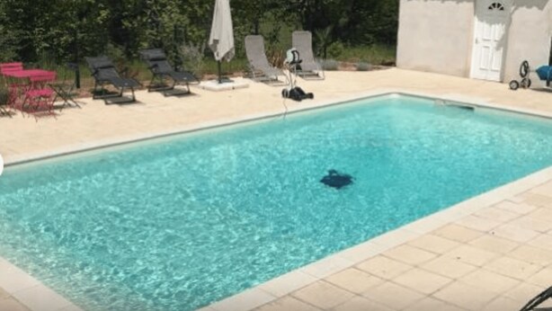 Une piscine rectangulaire à l’eau d’un bleu limpide, entourée d’une terrasse carrelée.