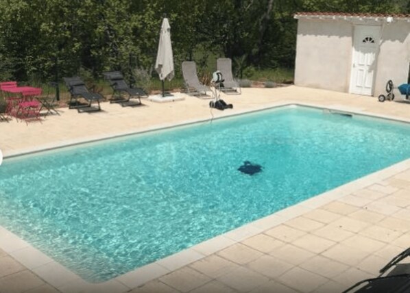 Una piscina rectangular con agua azul cristalina, rodeada por una solana con baldosas.