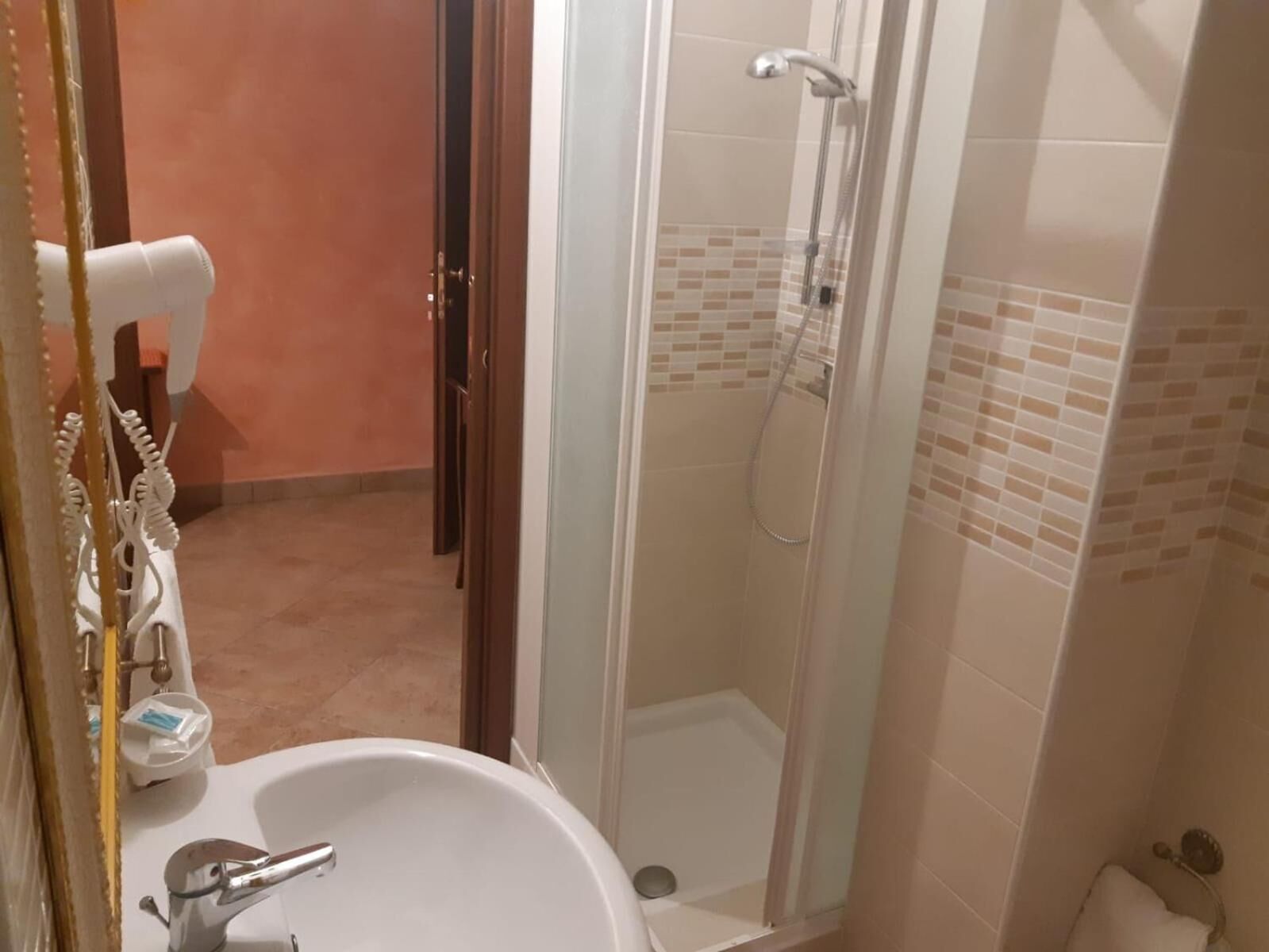 Un baño con ducha de vidrio, un lavamanos blanco y un inodoro.