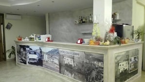A reception area with a marble counter, a wall-mounted air conditioner, and a shelf with various items. - Agriturismo Antica Casa Scardone (Piedimonte San Germano)