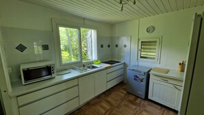 A compact kitchen with white cabinets, a microwave, a sink, and a small refrigerator. - Villa Ti Colibri in Sainte-Anne 350 m from the sea (Sainte-Anne)