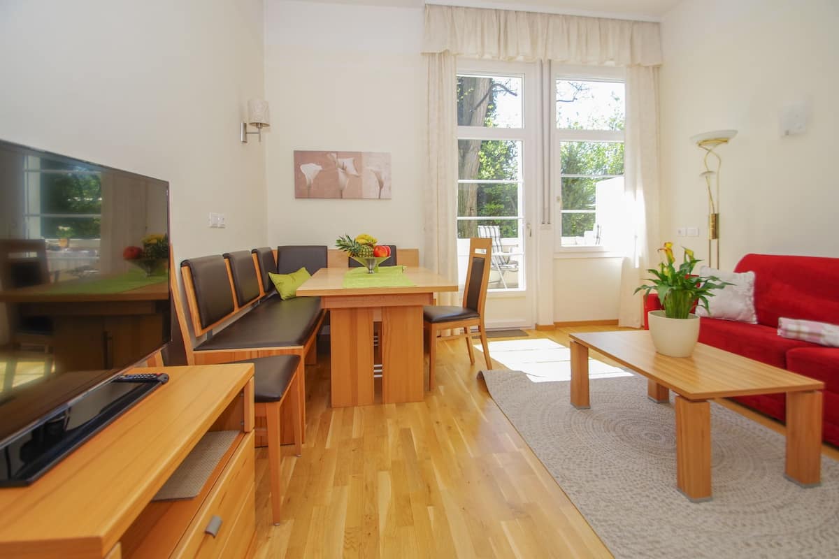 Un salon moderne avec une table à manger en bois, un canapé et un téléviseur.