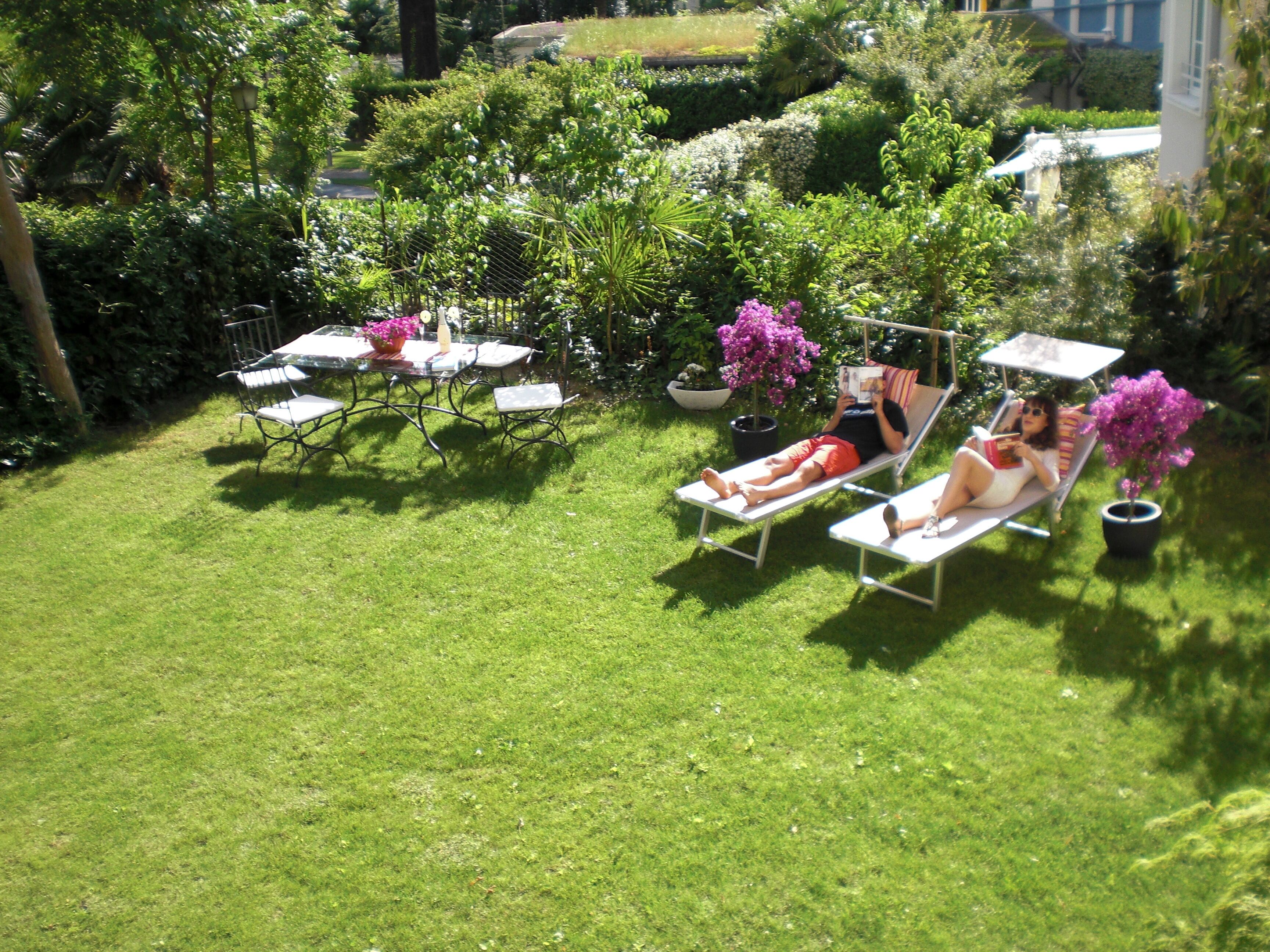 Ein Garten mit zwei Liegestühlen und einem Tisch.