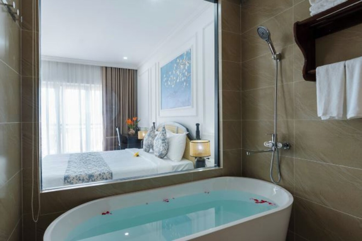 A modern bathroom with a freestanding bathtub, a large mirror, and a shower area.
