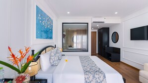 Quarto de hotel moderno com uma cama grande, televisão, espelho e janela com vista para o exterior.