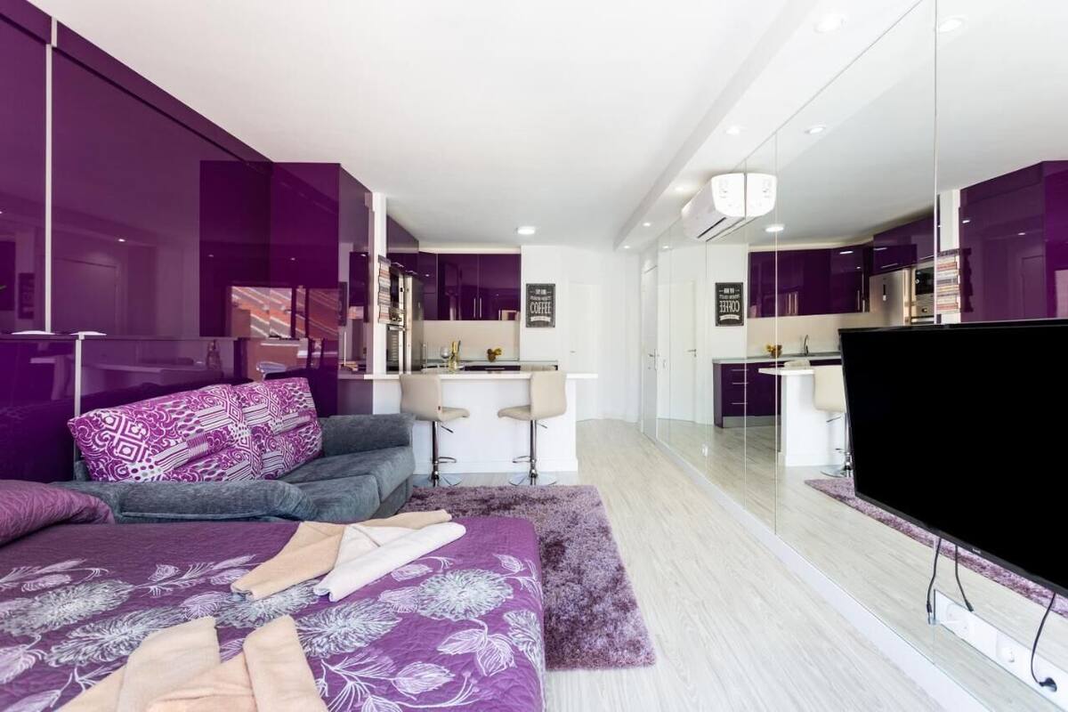 Une chambre à coucher moderne avec un lit, un bureau et un téléviseur.