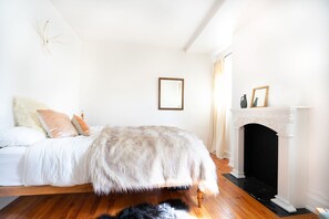 Ein Schlafzimmer mit einem Bett, einem Kamin und einer Felldecke.