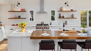 Een moderne keuken met een centraal eiland, witte kasten en een dakraam erboven.