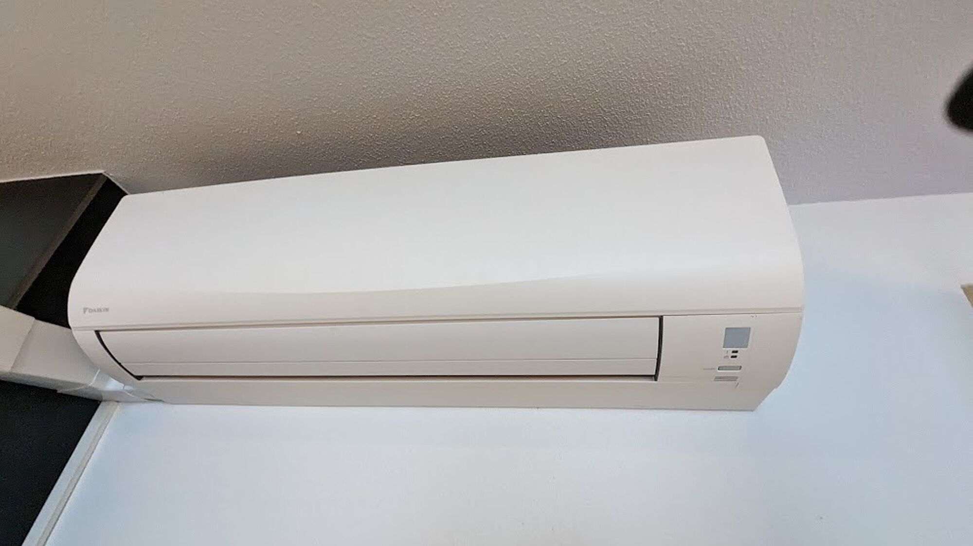 A white air conditioning unit on a white surface.