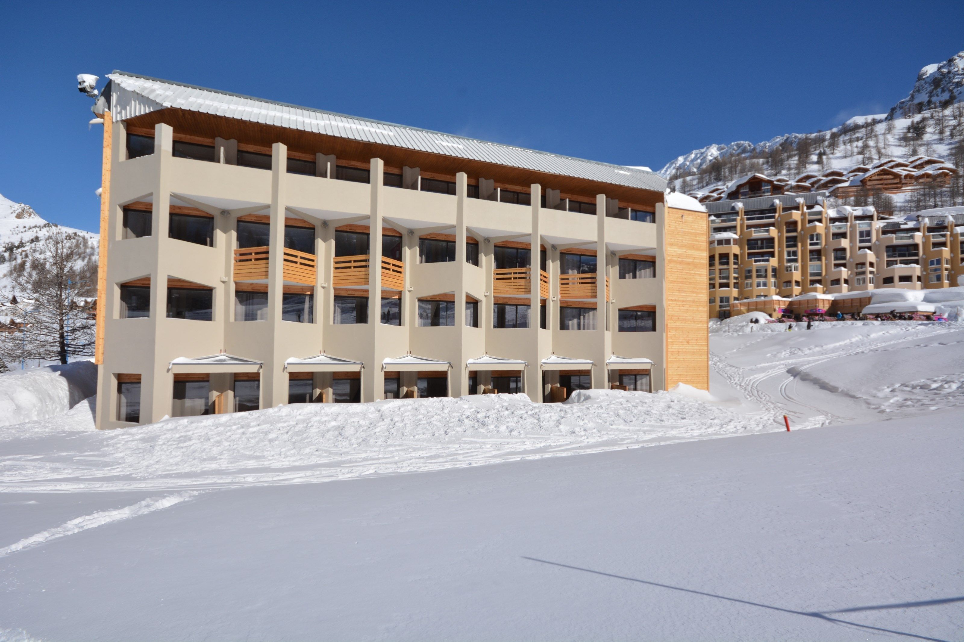 Ein mehrstöckiges Hotel mit modernem Design, mit Balkonen und großen Fenstern.