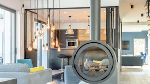 Un salon moderne doté d’une cheminée, de planchers en bois et de meubles contemporains.
