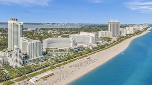 A coastal cityscape with high-rise hotels, a beachfront, and a marina.
