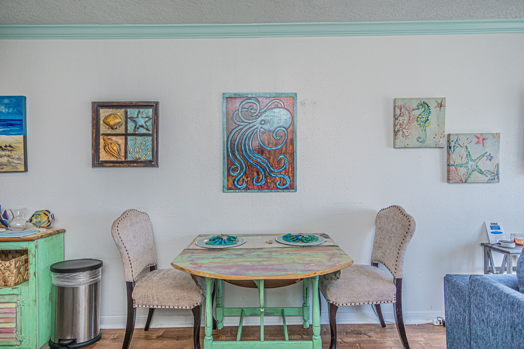 Un espace repas comprenant une table et des chaises, le tout agrémenté d’œuvres d’art exposées sur les murs.