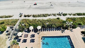 Et strandresort med swimmingpool, liggestole og parasoller.