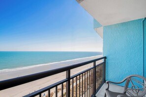 A balcony with a view of a beach and ocean.