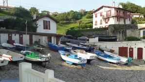 Une promenade au bord de l’eau pavée de pierres, où plusieurs petits bateaux sont amarrés côte à côte.
