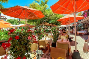 Enjoy al fresco dining under lush greenery and vibrant flowers.