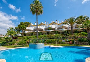 Relax by the hotel's rectangular pool surrounded by lush landscaping and palm trees.