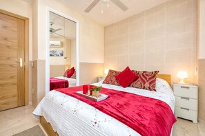 Relax in a comfortable bedroom with a large bed, a nightstand, and a mirror.