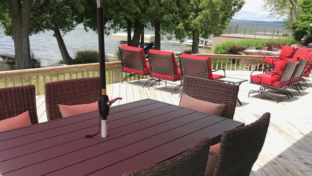 A deck with a table and chairs, overlooking a body of water. - Waterfront Vacation Home Directly on Hubbard Lake - East Shore (Spruce)