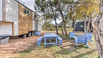 Una casa móvil con un patio que incluye una mesa de picnic y bancos.