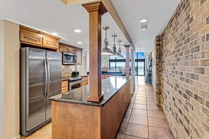 Enjoy cooking in this well-equipped kitchen with a central island, stainless steel appliances, and ocean views through large windows.