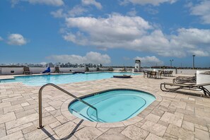 Relax by the rooftop pool, surrounded by lounge chairs and a hot tub, with breathtaking views of the coastal town.