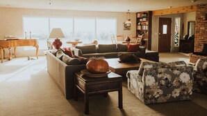 A cozy living room with a sofa, armchairs, a coffee table, and a fireplace.
