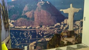 Un mural de Cristo Redentor con un paisaje urbano de fondo.