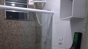 Un baño con ducha de vidrio, inodoro y lavamanos.