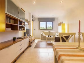 Een moderne, goed verlichte slaapkamer met een bed, nachtkastje en een groot raam.