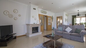 A living room with a fireplace, a sofa, a television, and a coffee table.
