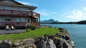 A lakeside property with a wooden deck, lounge chairs, and a view of the lake and mountains. - Waterfront only 2 miles from downtown!  Sleeps 8. Amazing Views! (Ketchikan)