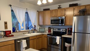 A modern kitchen with wooden cabinets, stainless steel appliances, a built-in oven, and a microwave. - Waterfront only 2 miles from downtown!  Sleeps 8. Amazing Views! (Ketchikan)